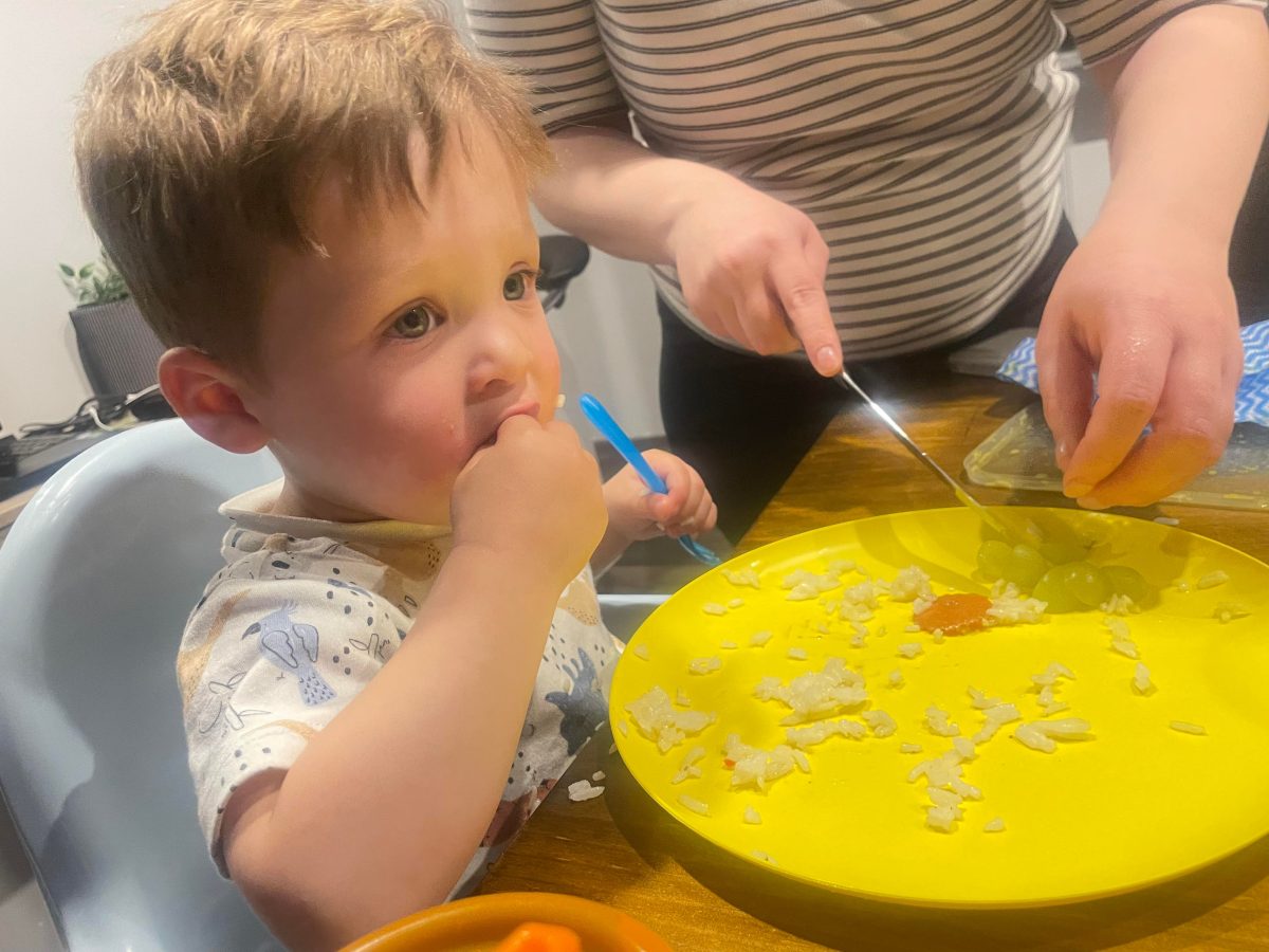 boy eating rice and grapes