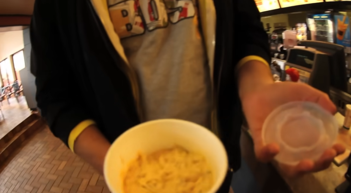 A paper soft drink cup filled with Big Mac sauce at a McDonald's counter, from Epic Meal Time's Fast Food Lasagna video