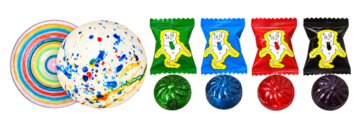 A giant jawbreaker cut in half showing its rainbow layers next to a whole speckled one, and Ghost Drops lollies in green, blue, red and black ghost wrappers