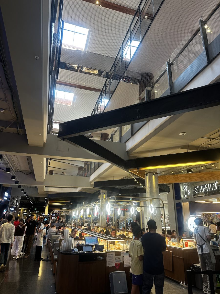 Looking up from the sushi train level at Highpoint towards the skylights, with black safety netting visible across the void
