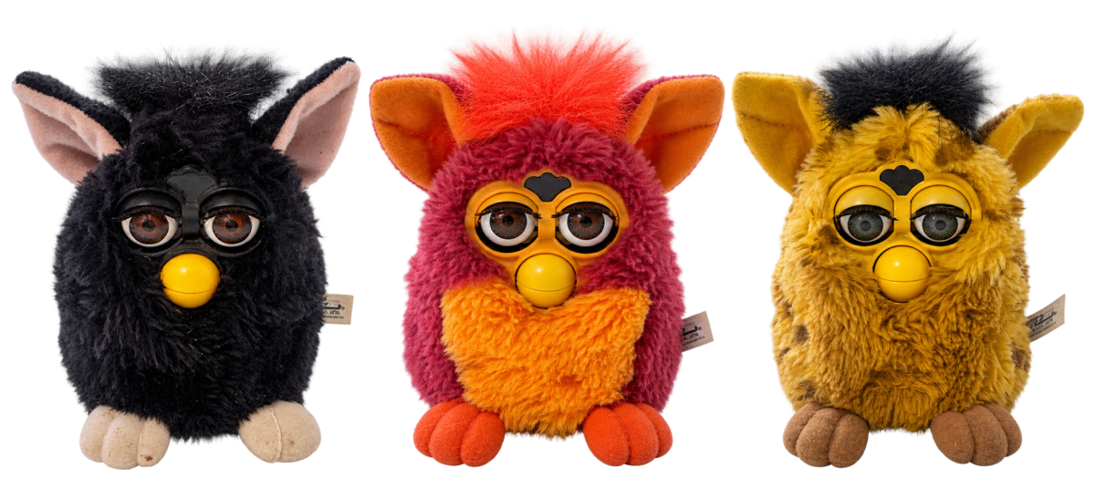 Three original 1998 Furby toys in black, red with orange belly, and yellow with brown spots